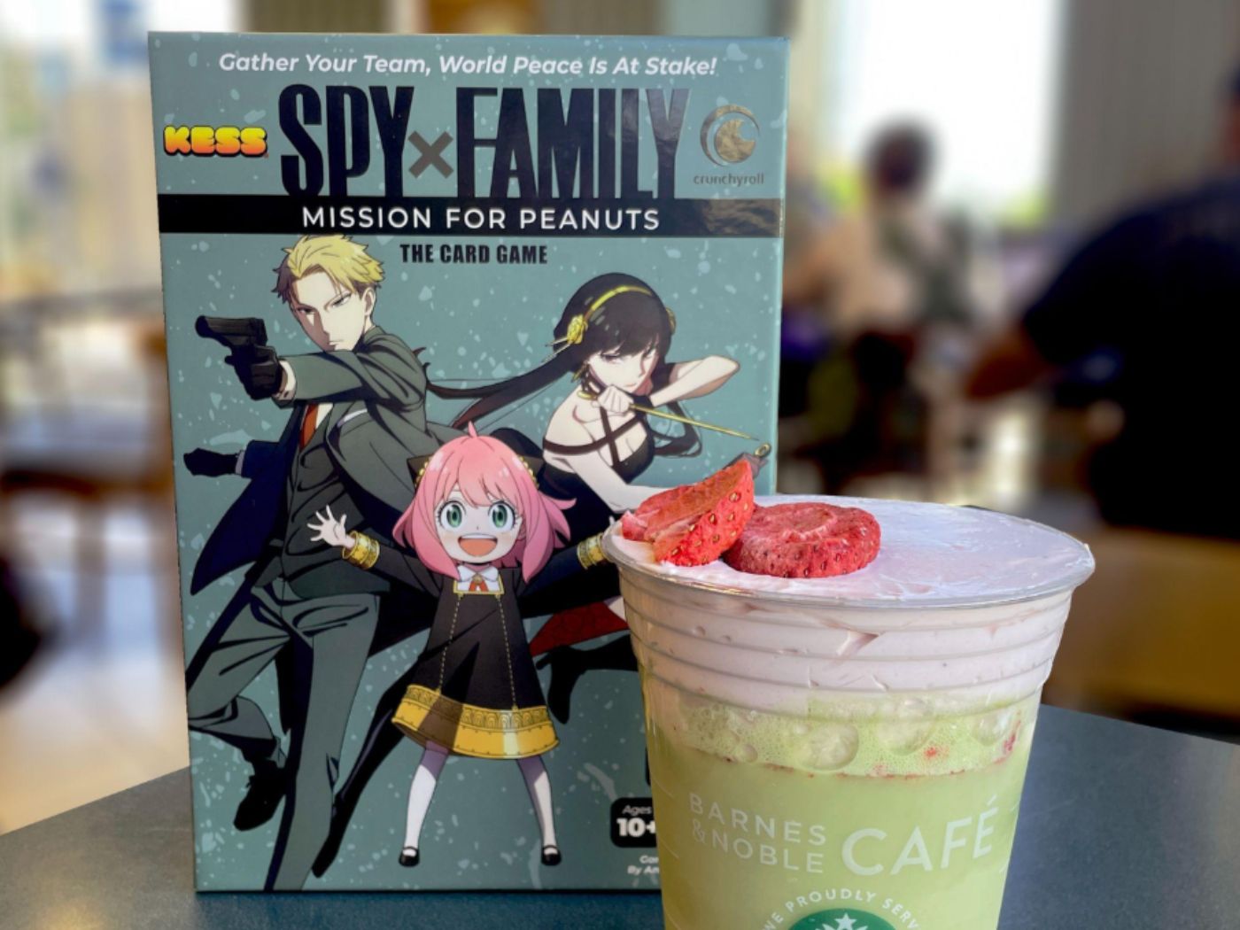 Spy x Family: Mission for Peanuts game box next to a themed Barnes & Noble café drink